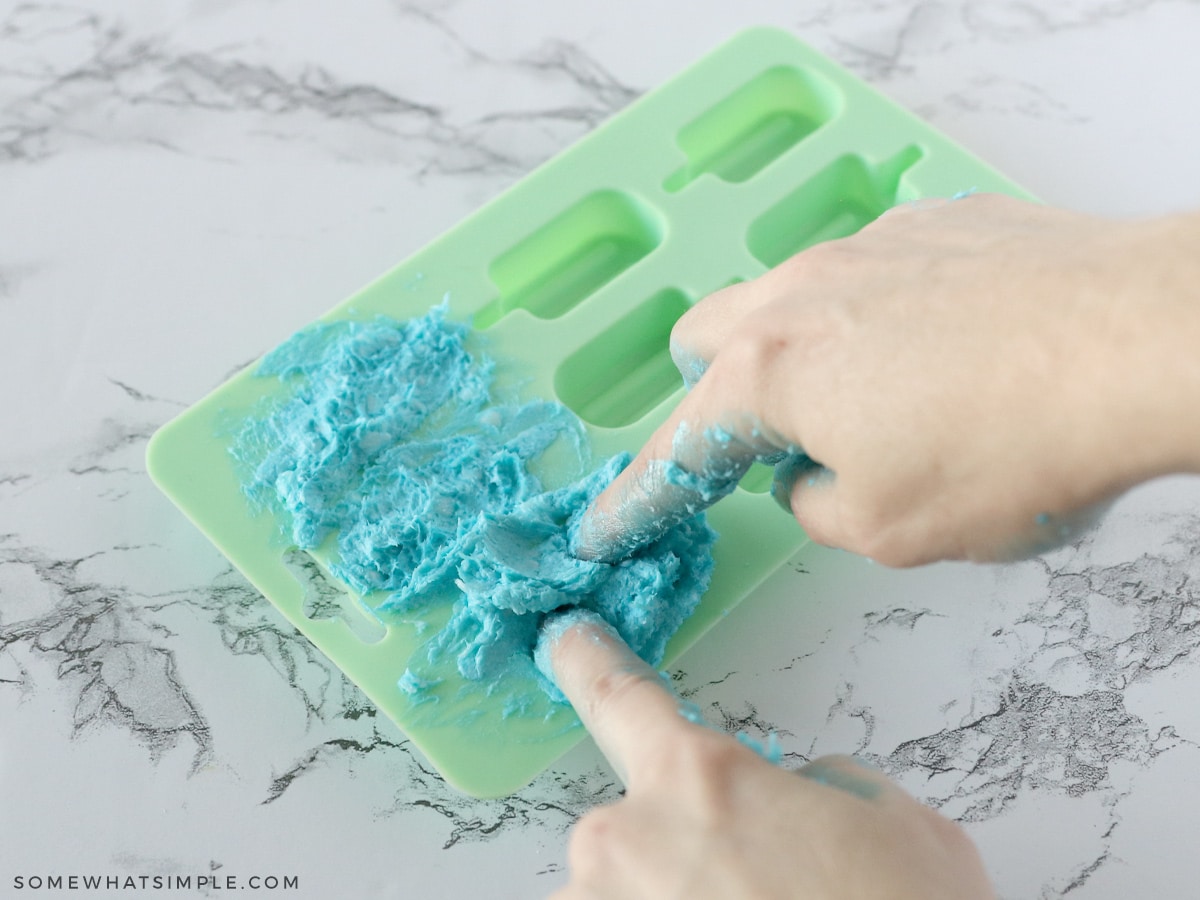 presing soap into a silicone popsicle mold