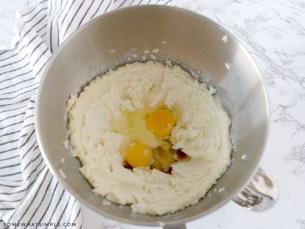 adding eggs to a cookie dough bowl