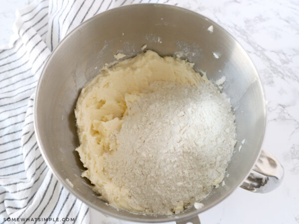 adding dry ingredients to a mixing bowl