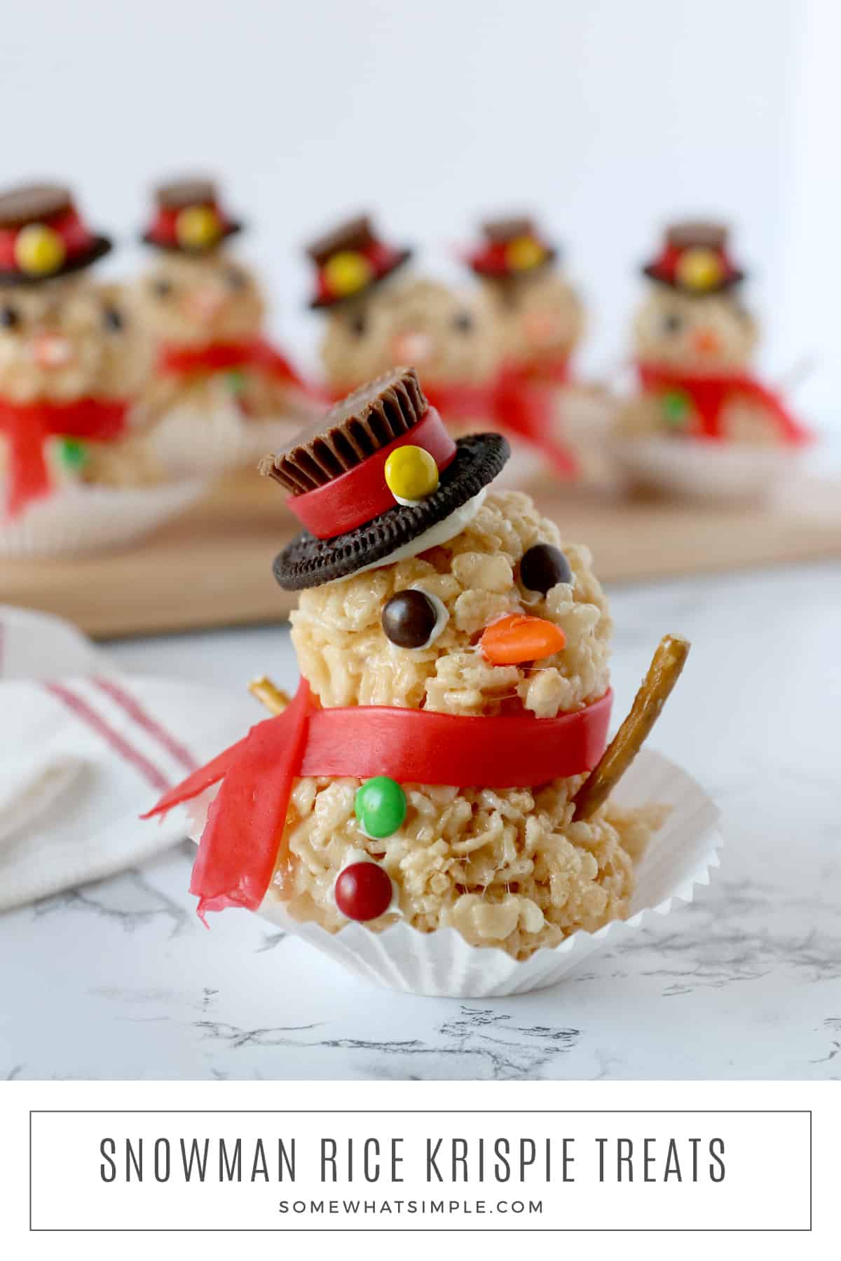 Snowman Rice Krispie treats are a fun holiday activity for kids that doubles as a tasty treat! These easy snowman treats are made with delicious peanut butter cups, M&M's, and other delicious candies that everyone is sure to love! via @somewhatsimple
