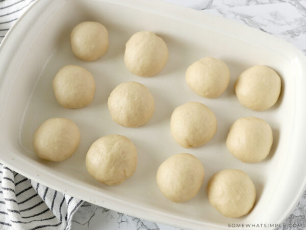 raw dough balls in a baking pan