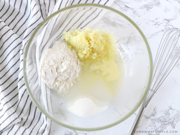 adding ingredients for lemon souffles to a glass bowl