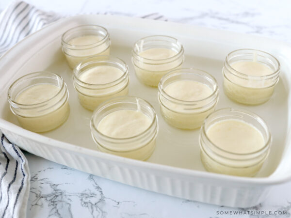 adding water to a glass pan with lemon souffle glasses lined up