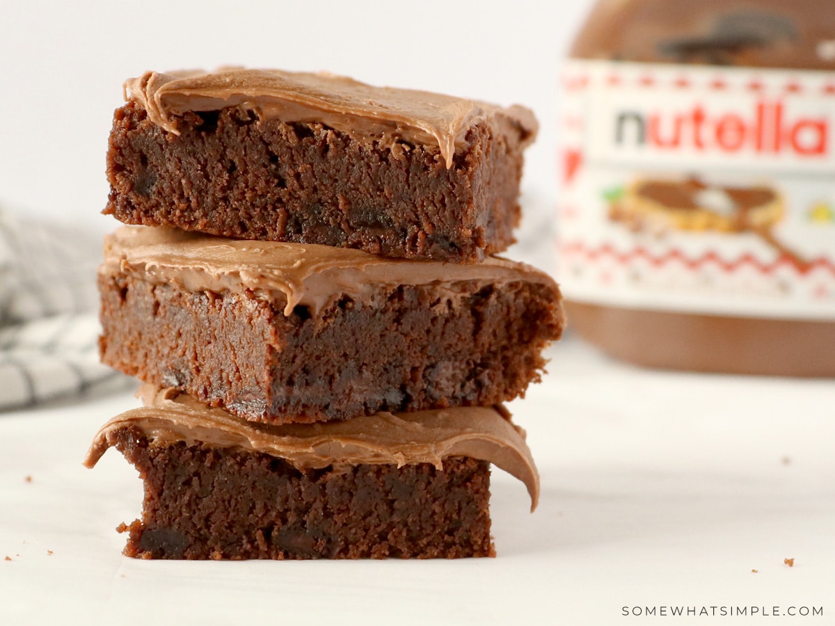 stack of brownies with a jar of nutella in the backgrounf