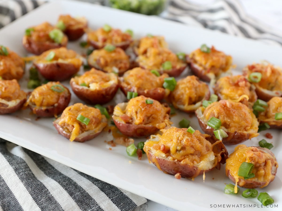 plated mini potato skins with green onions on top of the melted cheese