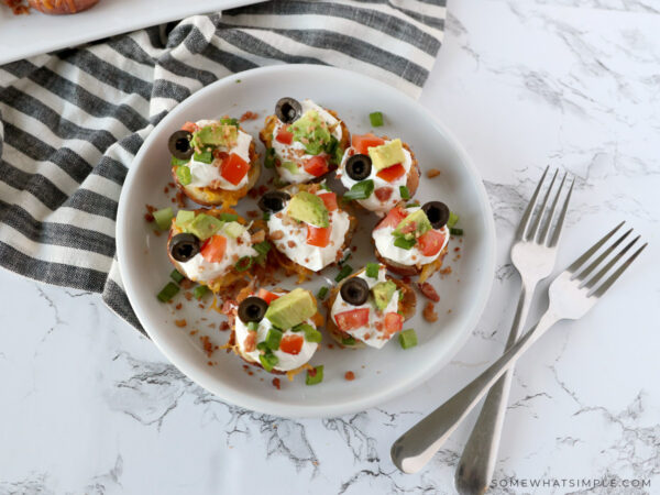 potato skins topped with sour cream, olives, and diced tomatoes