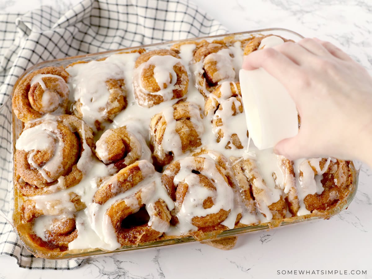 pouring icing over 30-minute cinnamon rolls