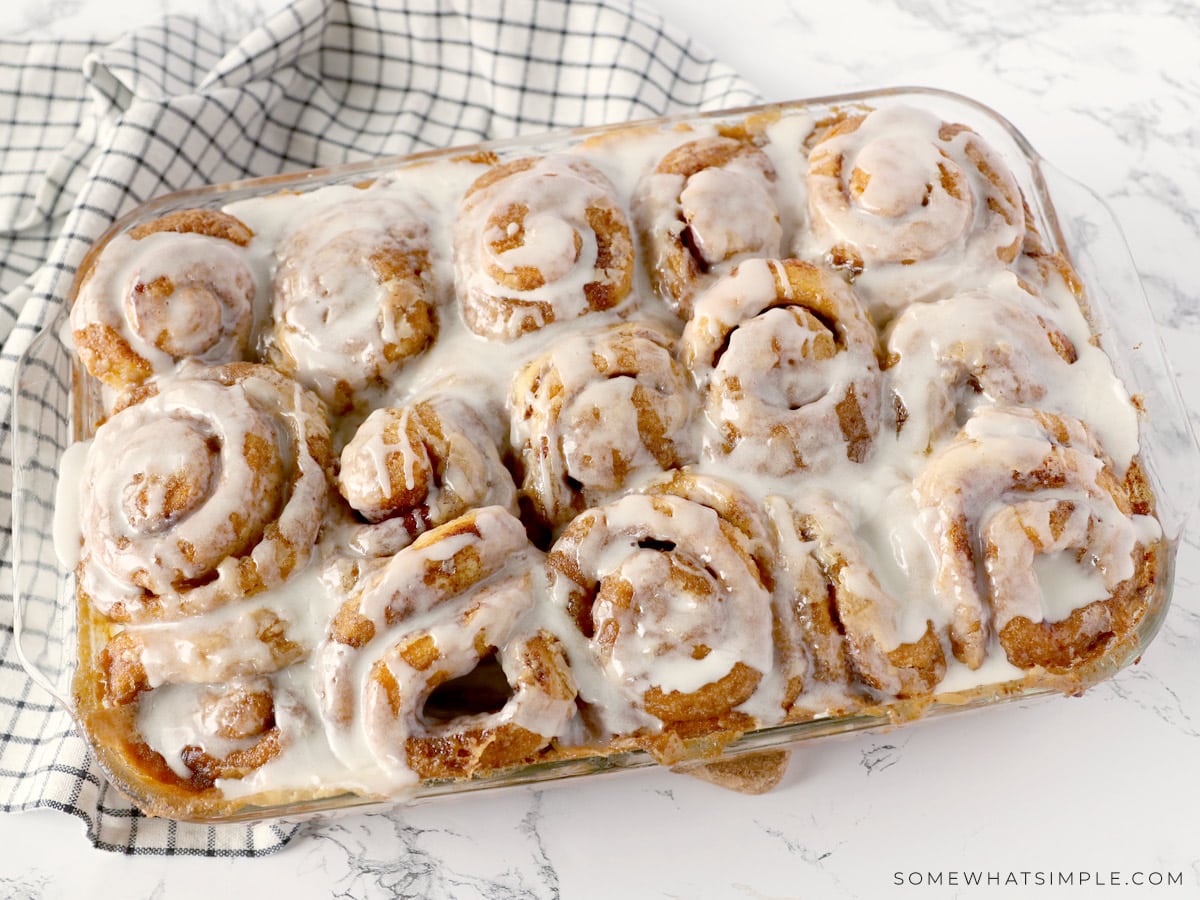 iced cinnamon rolls in a glass baking dish