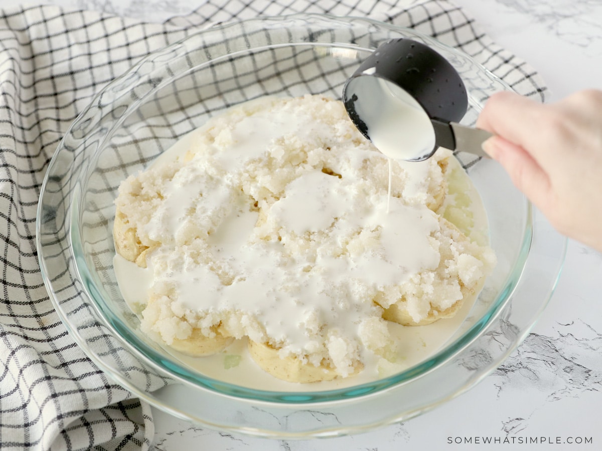 pouring heavy cream over raw orange roll dough