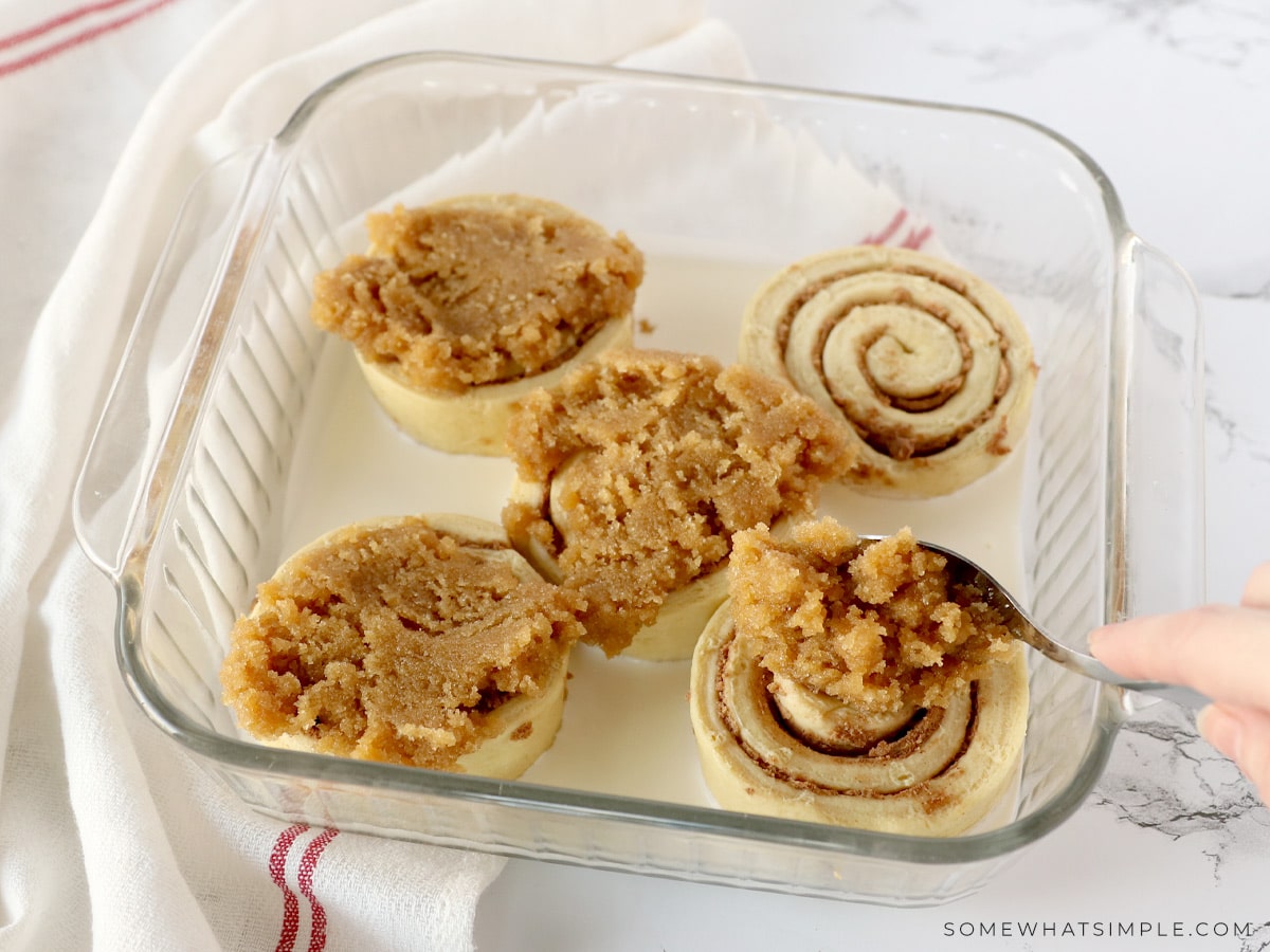 adding a cinnamon topping to the top of refrigerated rolls