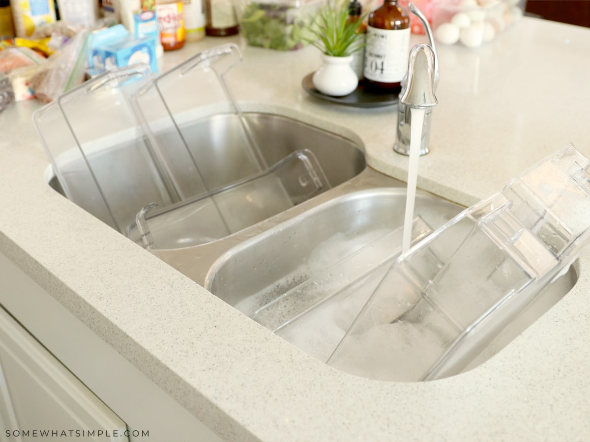 rinsing fridge shelves in hot soapy water