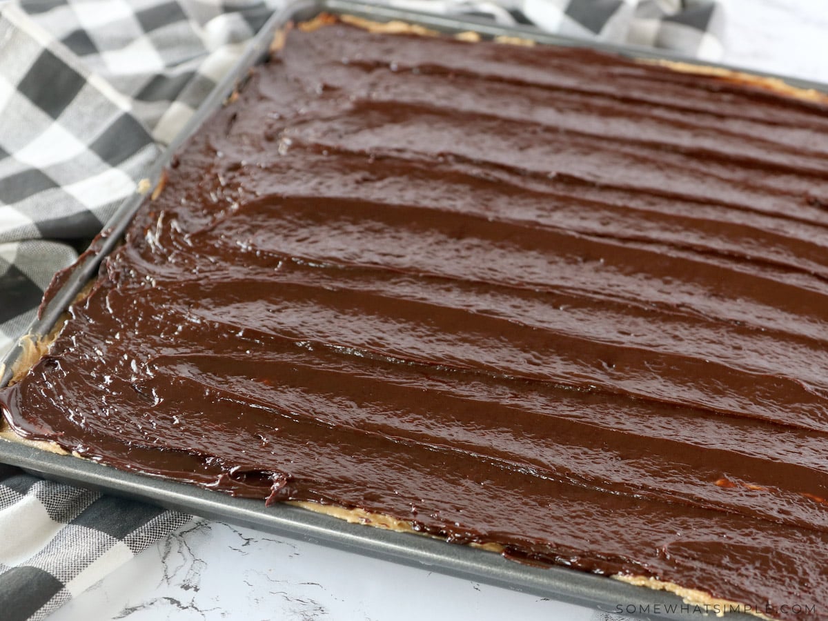 adding a chocolate ganache to peanut butter bars