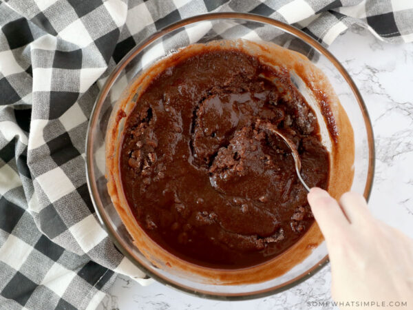 mixing brownie batter in a glass bowl