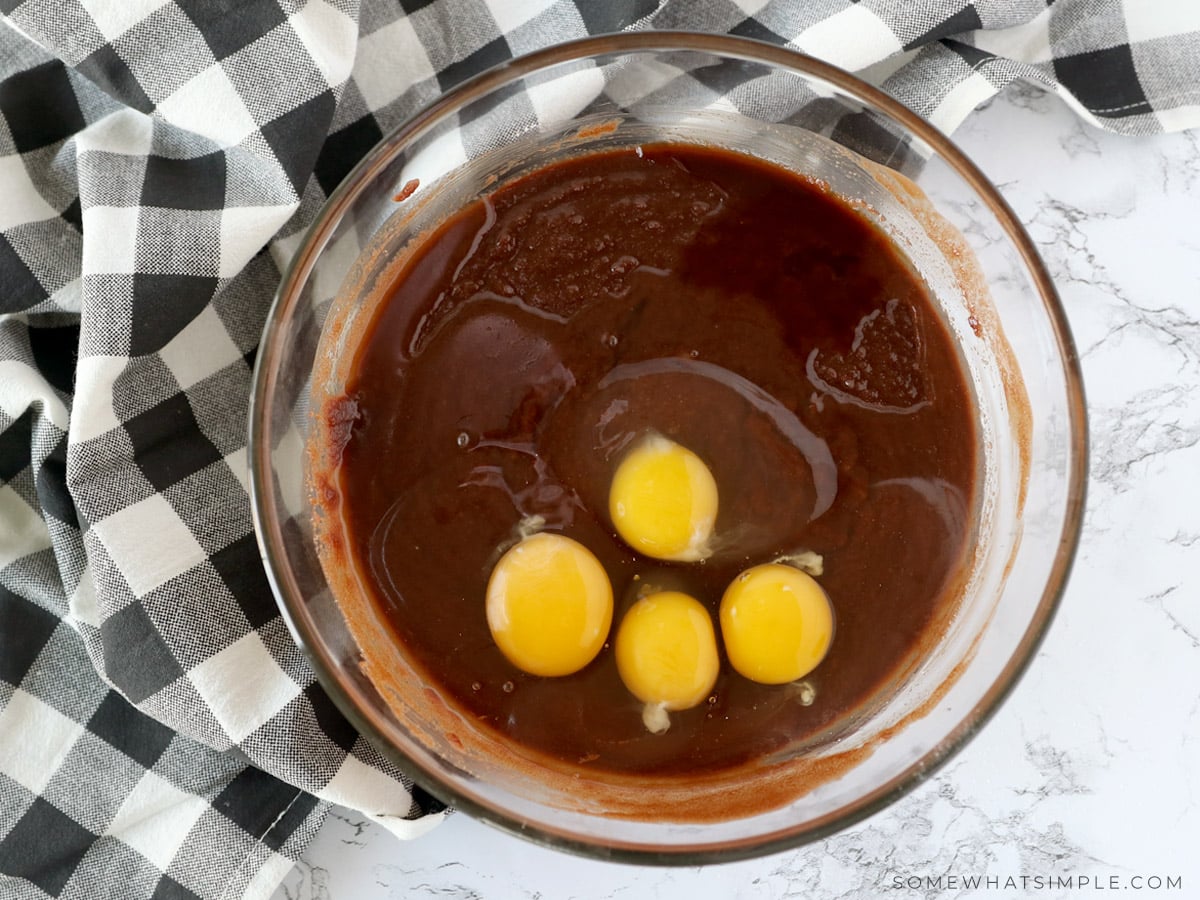 adding eggs to a brownie mixture