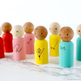 wooden spool dolls lined up on a counter