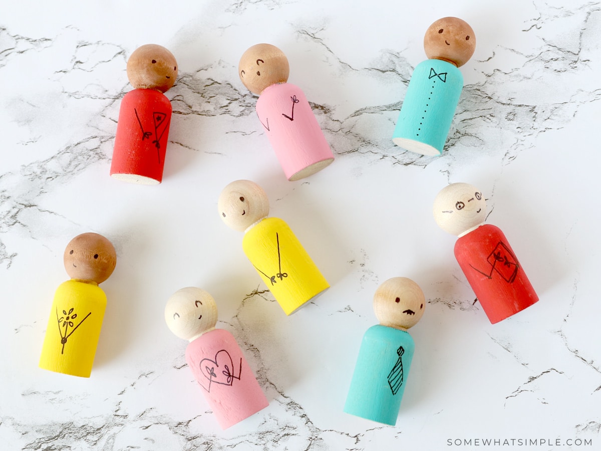 wooden spool dolls laying on a white counter