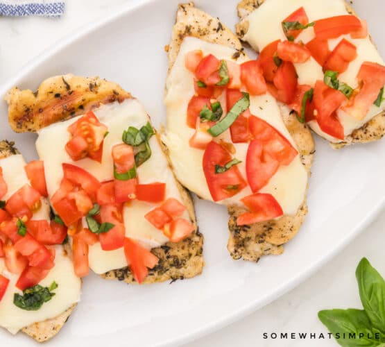 plated chicken breasts with cheese and bruschetta on top