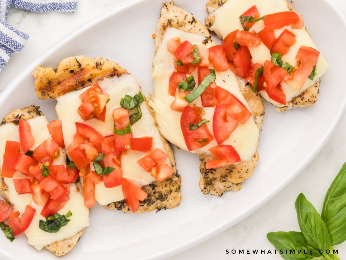 plated chicken breasts with cheese and bruschetta on top