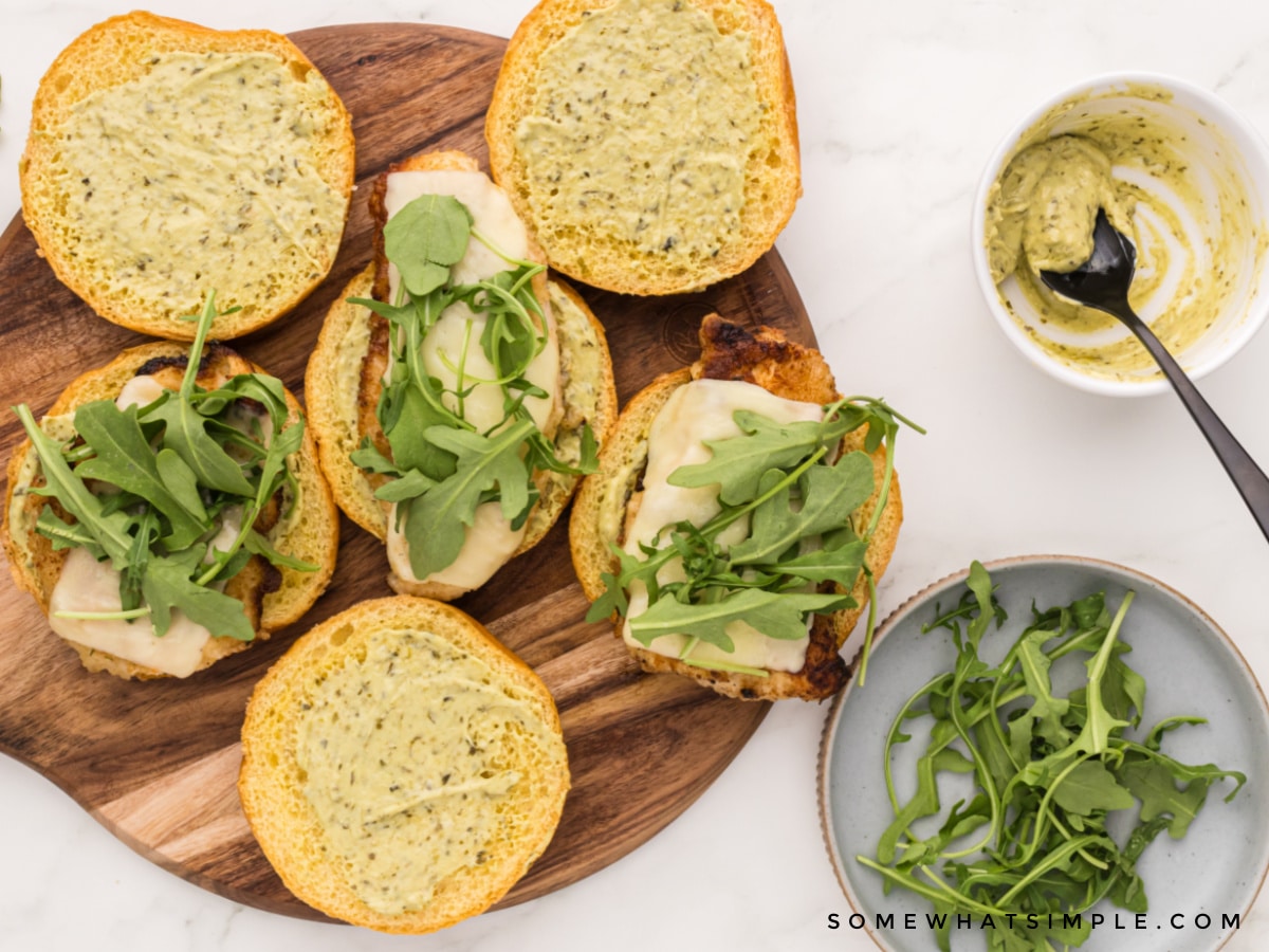 building a chicken sandwich with sauce and arugula
