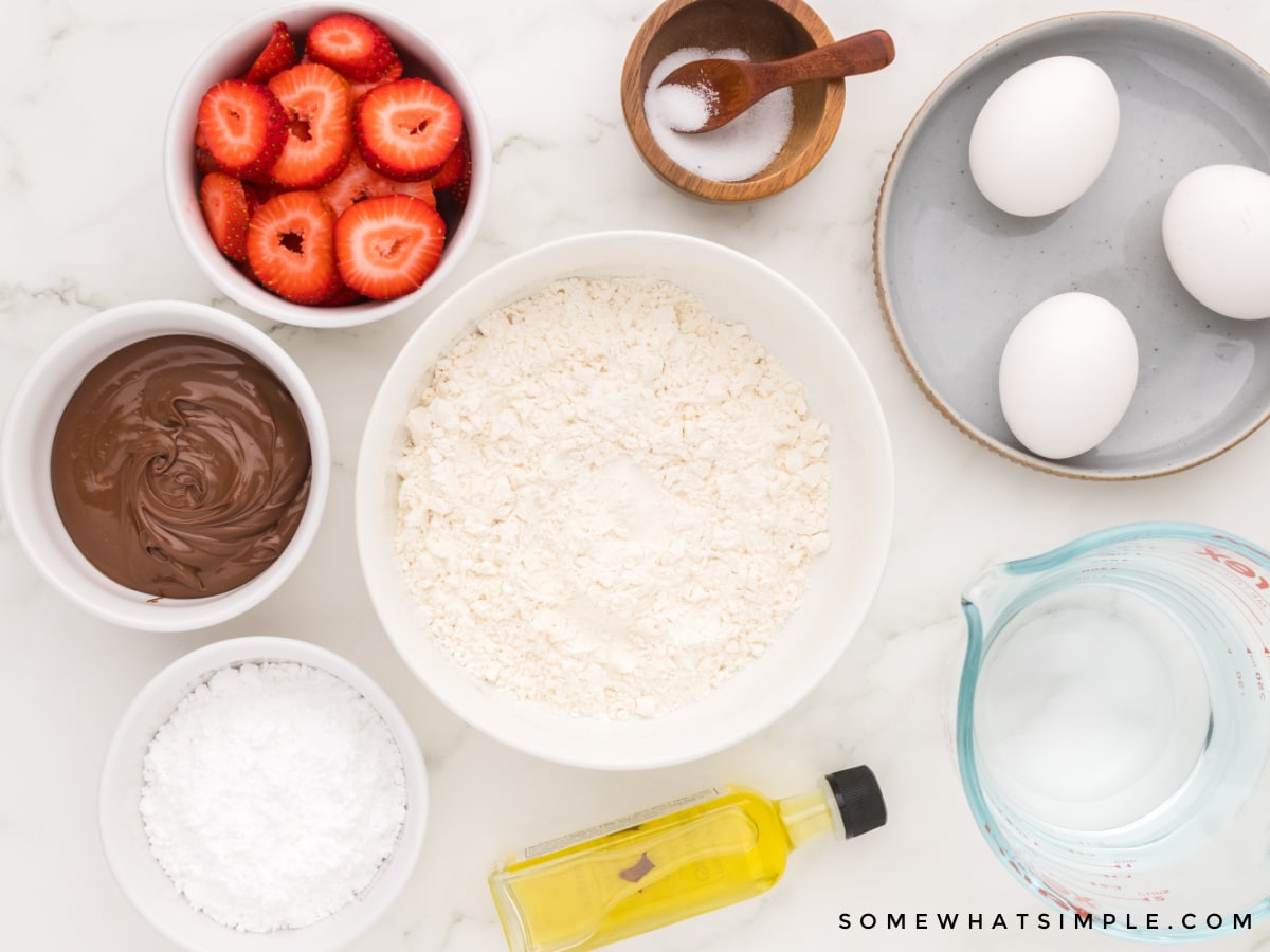 ingredients to make crepes on a white counter