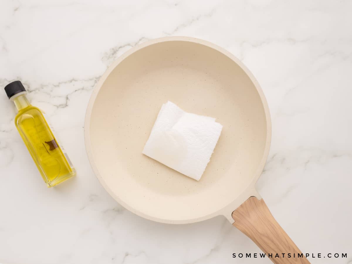 rubbing a paper towel on a skillet