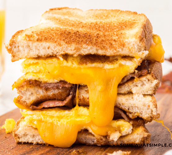 finished scrambled egg sandwich with cheese oozing down the sides