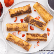 photo of French toast rollups on a white plate with strawberries