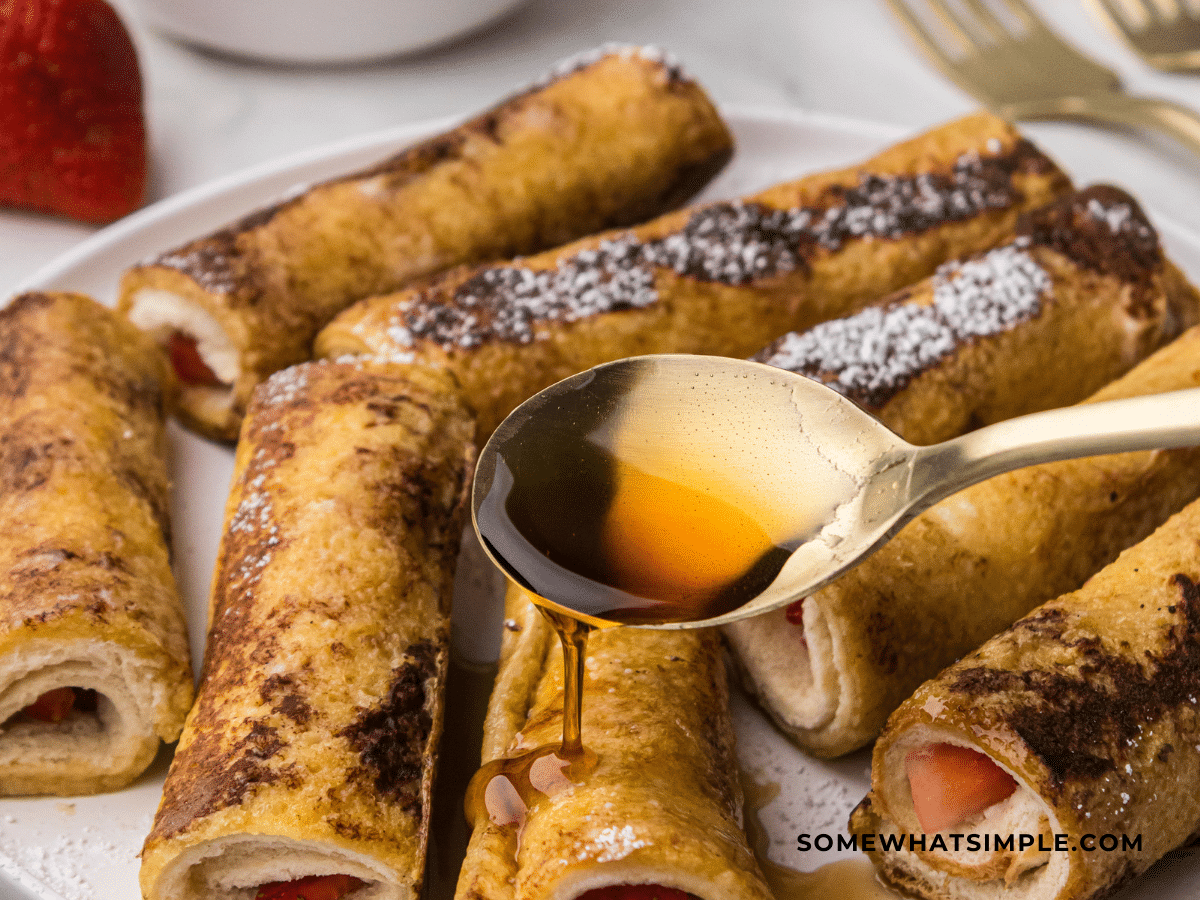 photo of French toast rollups on a plate with syrup being drizzled over it