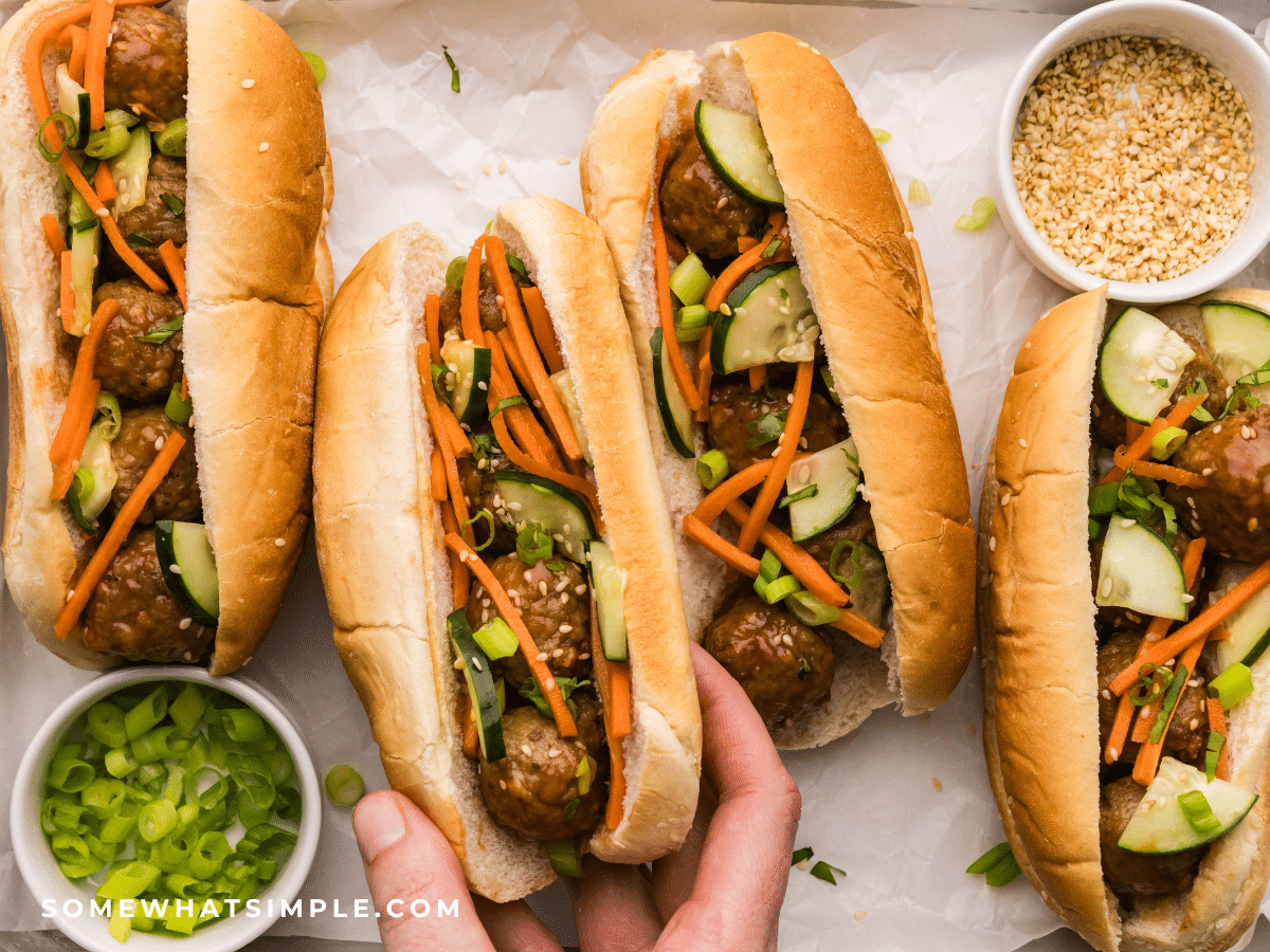 womans hand grabbing 1 Asian Meatball Sandwiche