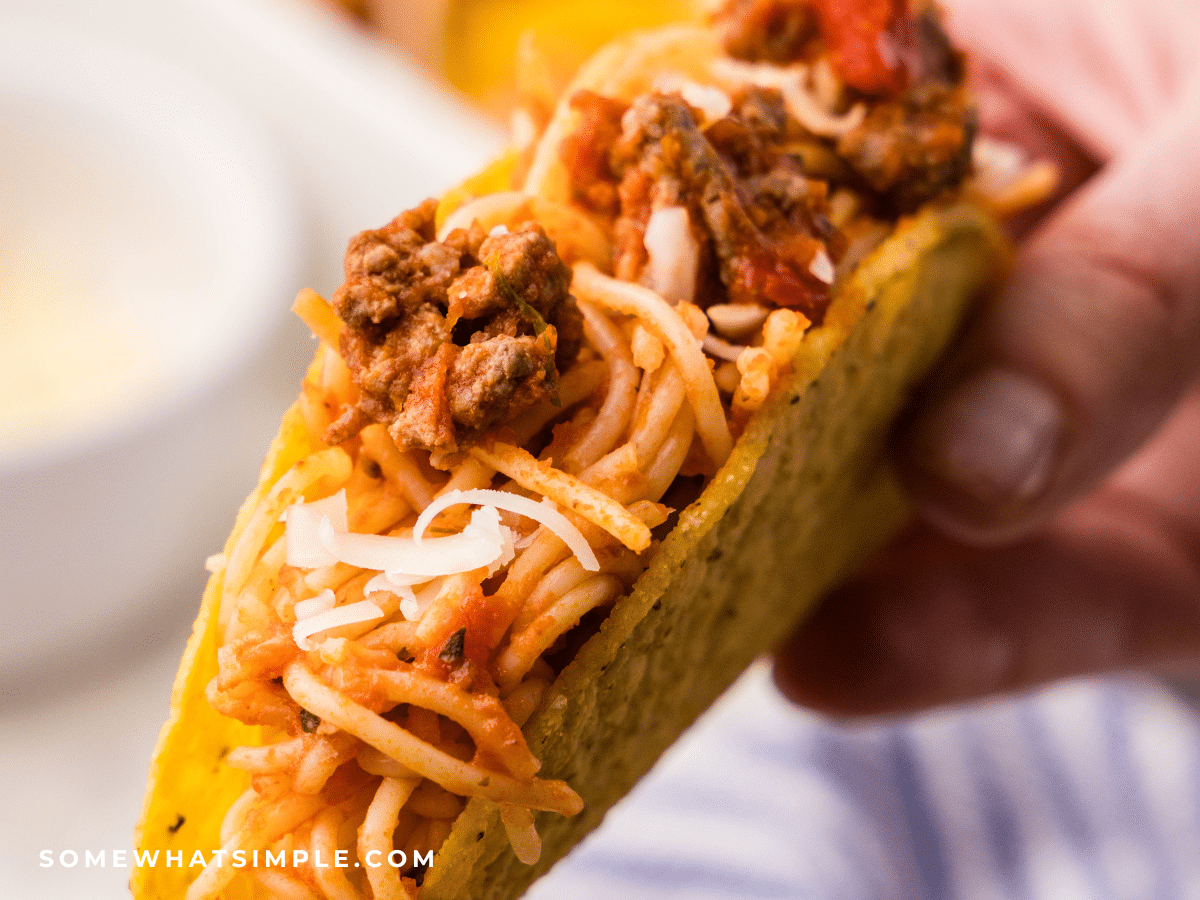 close up of a hand holding a Spaghetti Taco