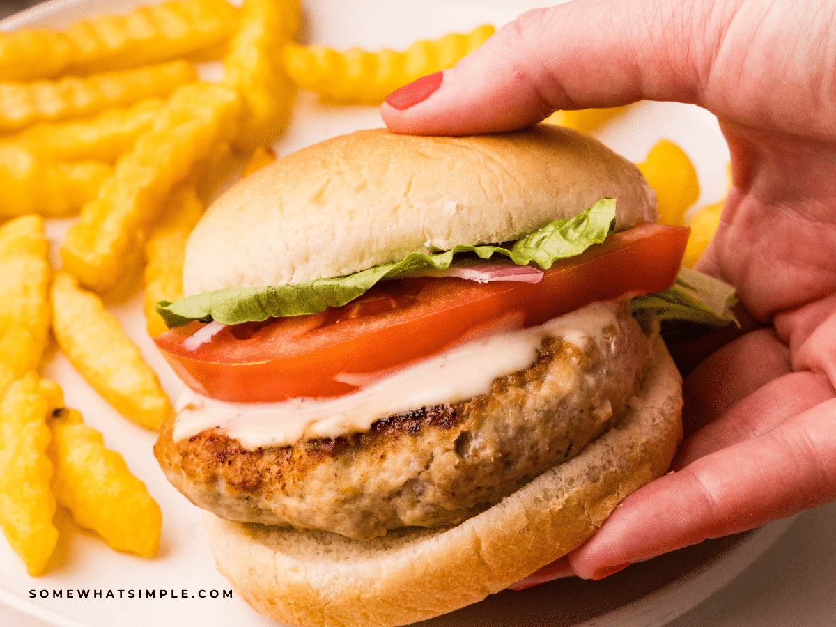 hand holding a Chicken Caesar Burger