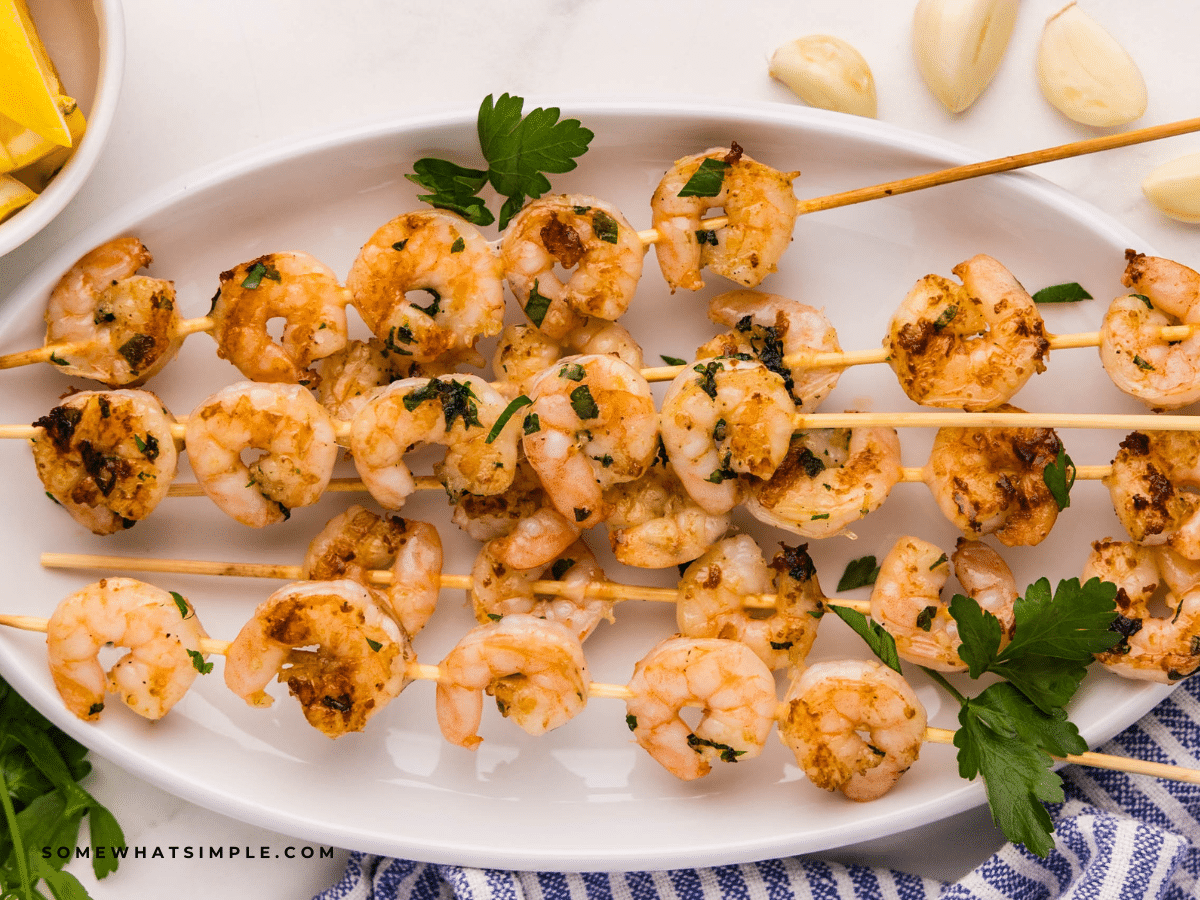 Grilled Garlic Shrimp on skewers, plated on a white plate