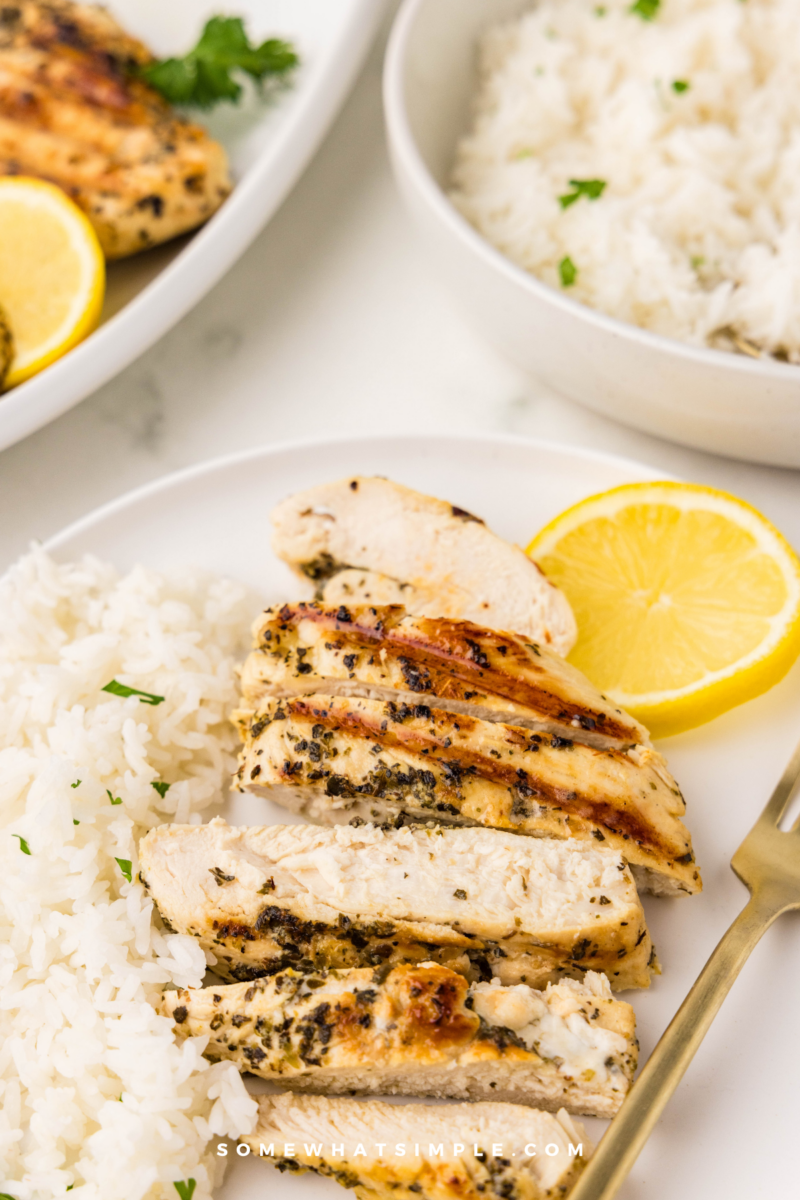 plated marinated italian chicken breasts next to rice