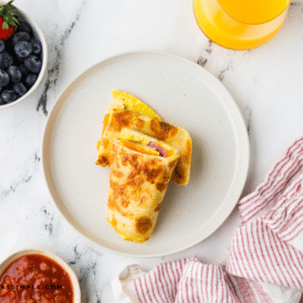 plated Tortilla Breakfast Wrap on a white plate next to berries