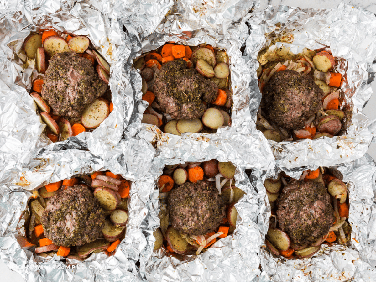 6 Beef and Potato Foil Packet Dinners on a baking sheet